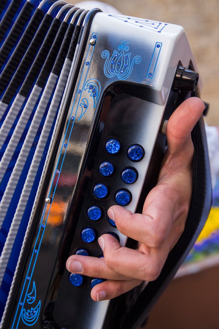 Detailed shot of a musician's hand playing an accordion in Barcelos, Portugal.