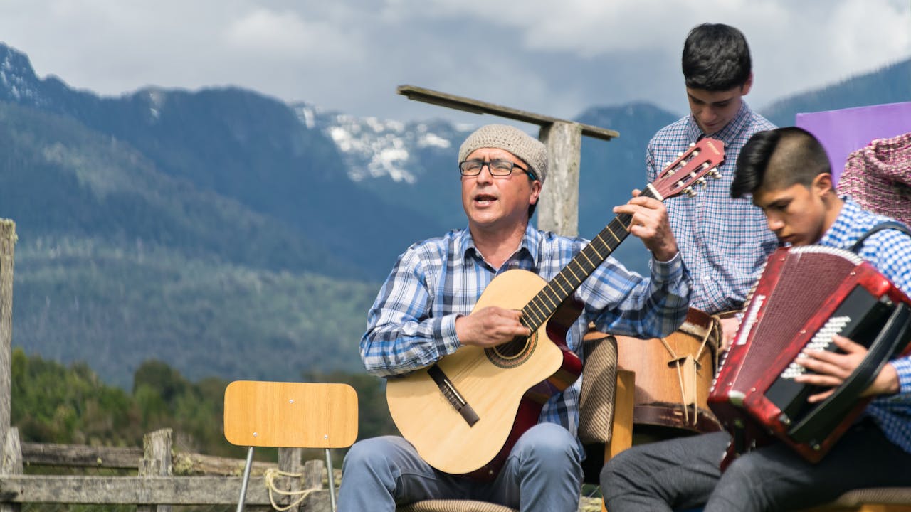 A passionate group of musicians performing outdoors in Huequi, Chile, featuring guitars and accordions.